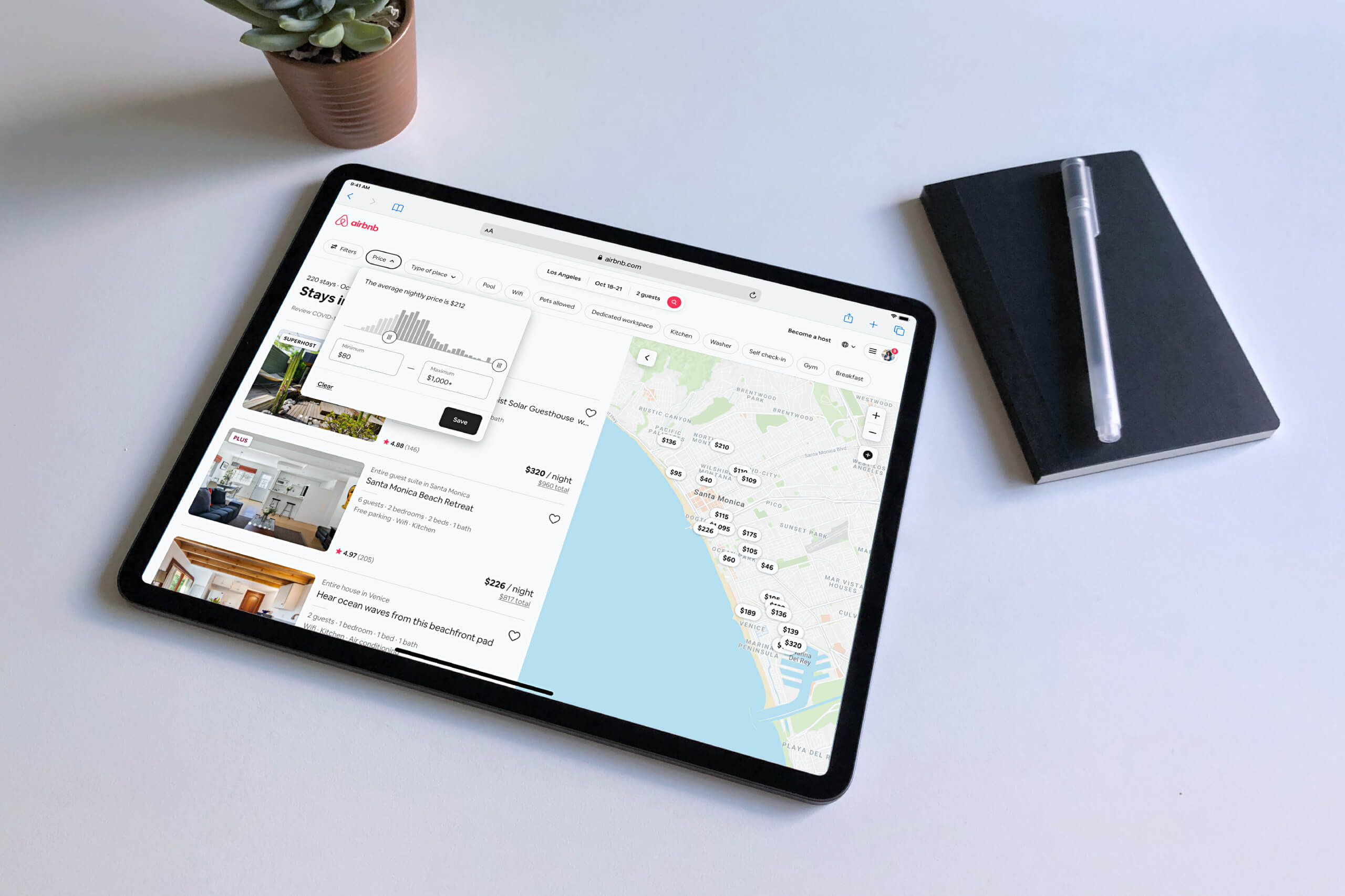 iPad Pro laying on table showing the Airbnb search results page and map view of Los Angeles